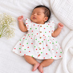 My Mini Buds white muslin baby girl frill frock with red and green heart print, layered ruffle sleeves and a button-down front.Newborn baby wear